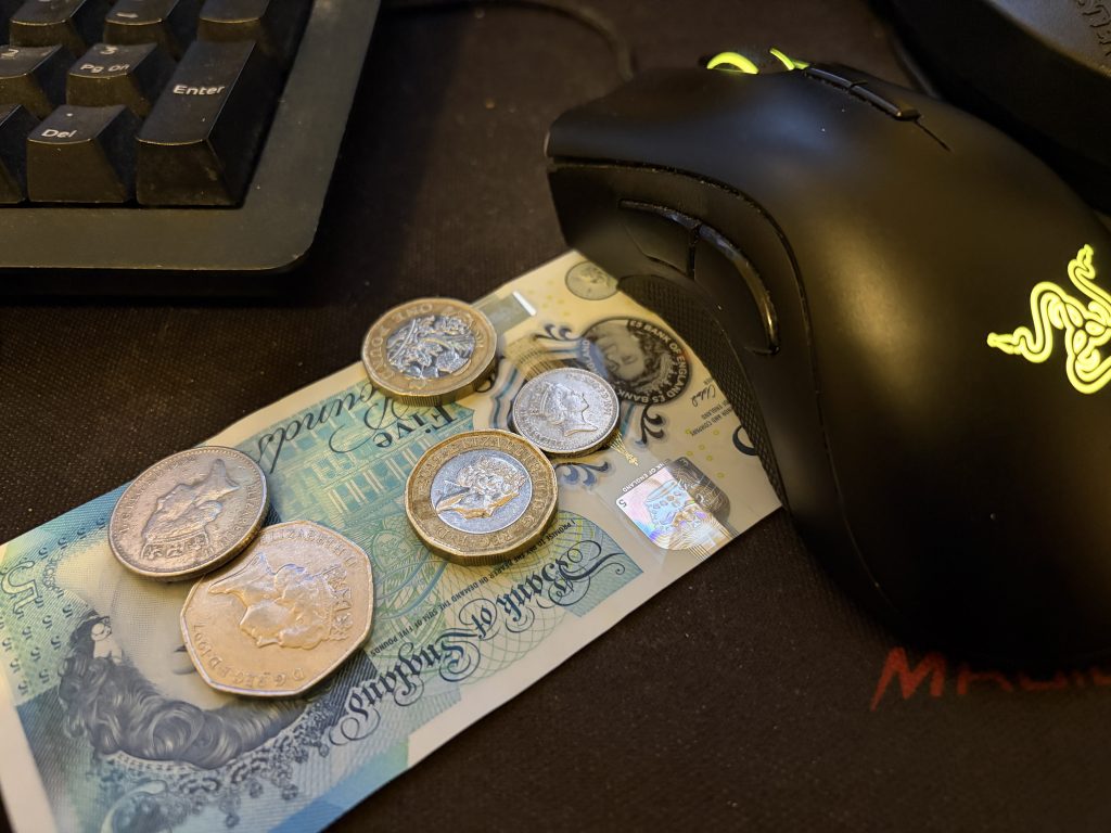 Close up image of some money next to a mouse and keyboard