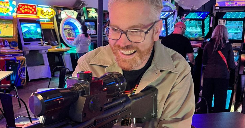 Image of James Baker hitting the mark and playing an arcade game in Bury Arcade Club